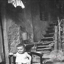 Bambino su poltroncina nel cortile dei Ciness